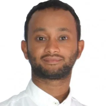 Portrait of Zakariae Jaafari in a white shirt, against a light background.